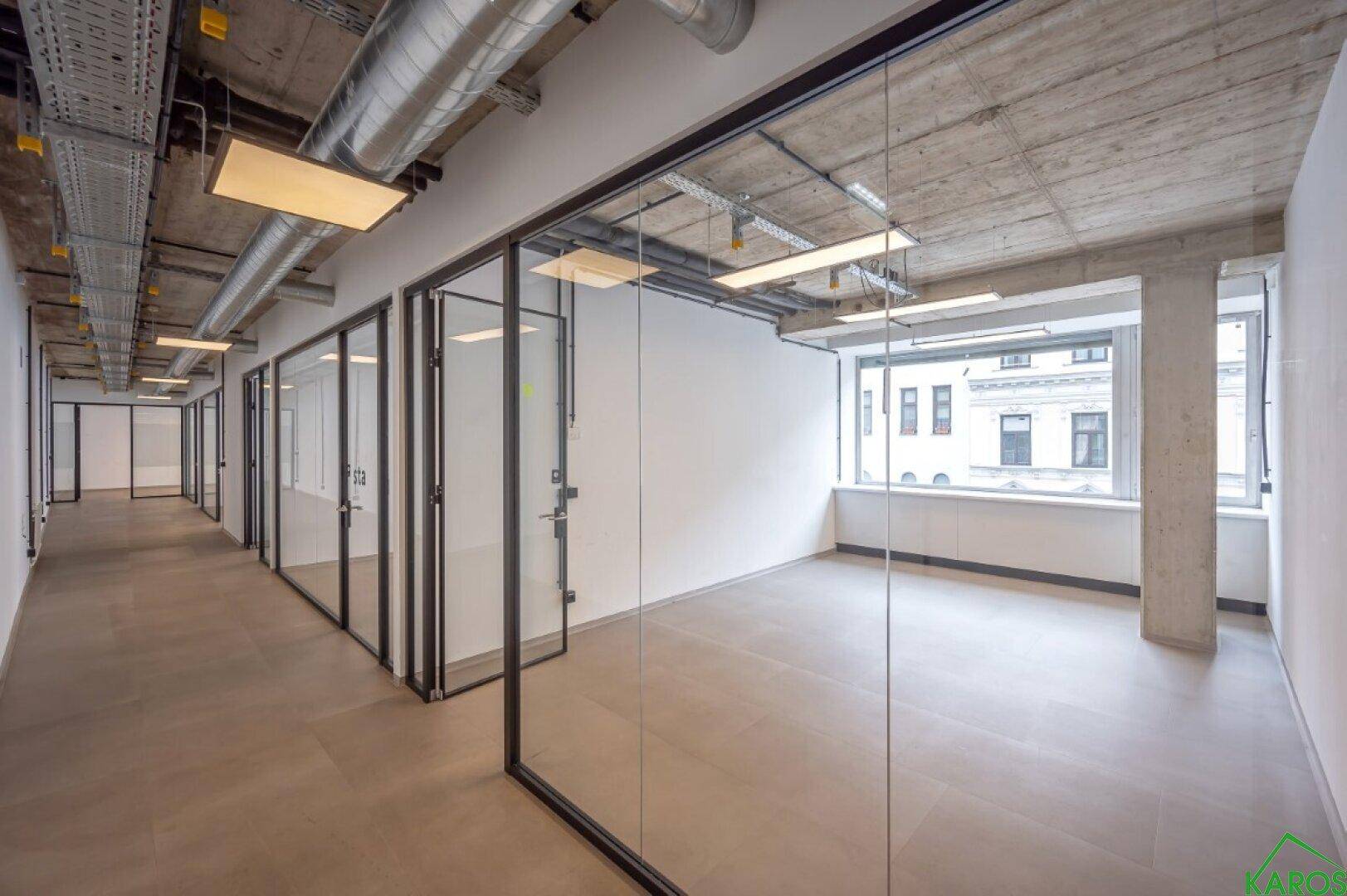 Helles Büro mit Glaswänden und einer breiten Fensterfront, die viel Licht spendet.