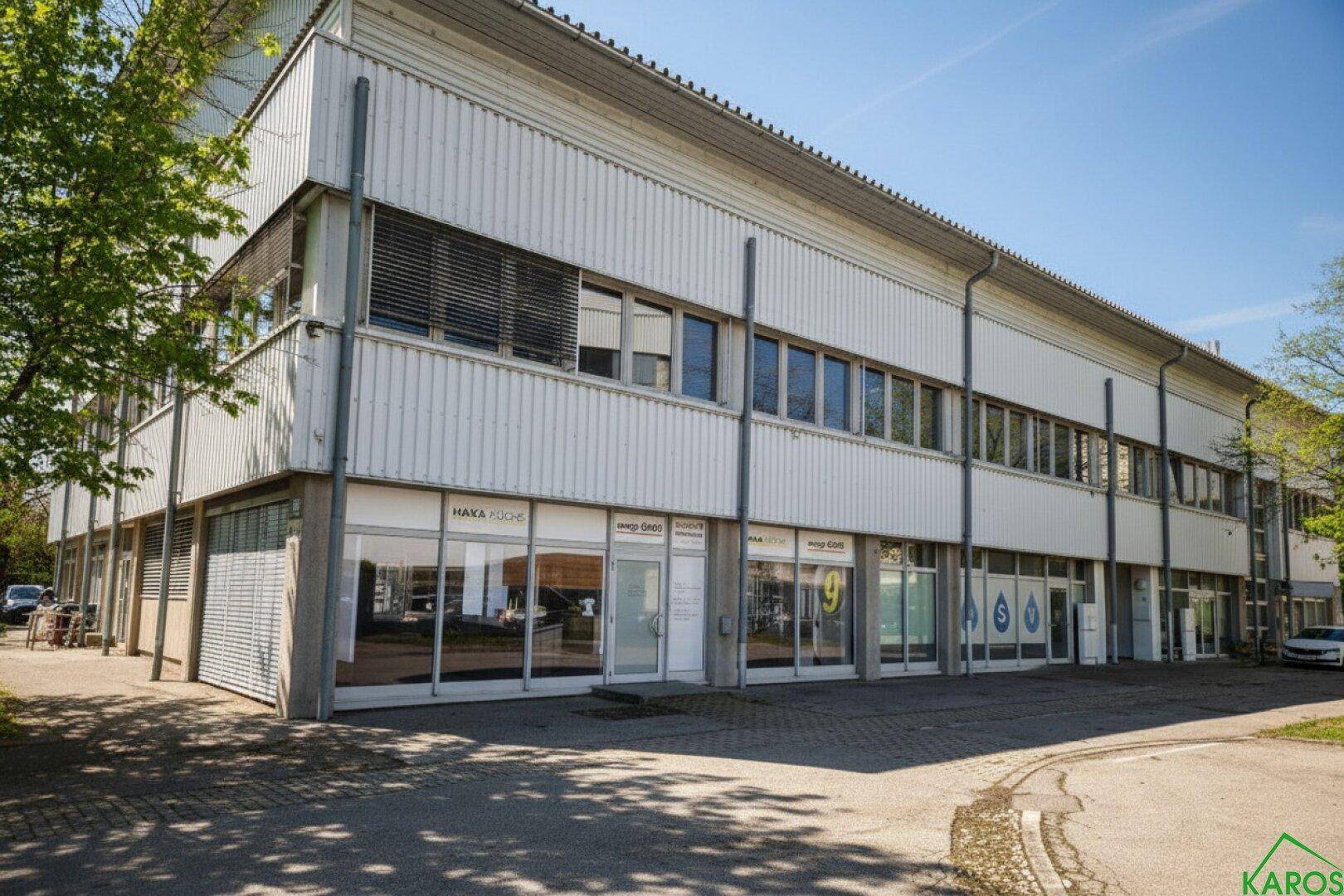 Eckansicht eines modernen Geschäftsgebäudes mit vielen Fenstern und Lamellen an der Fassade.