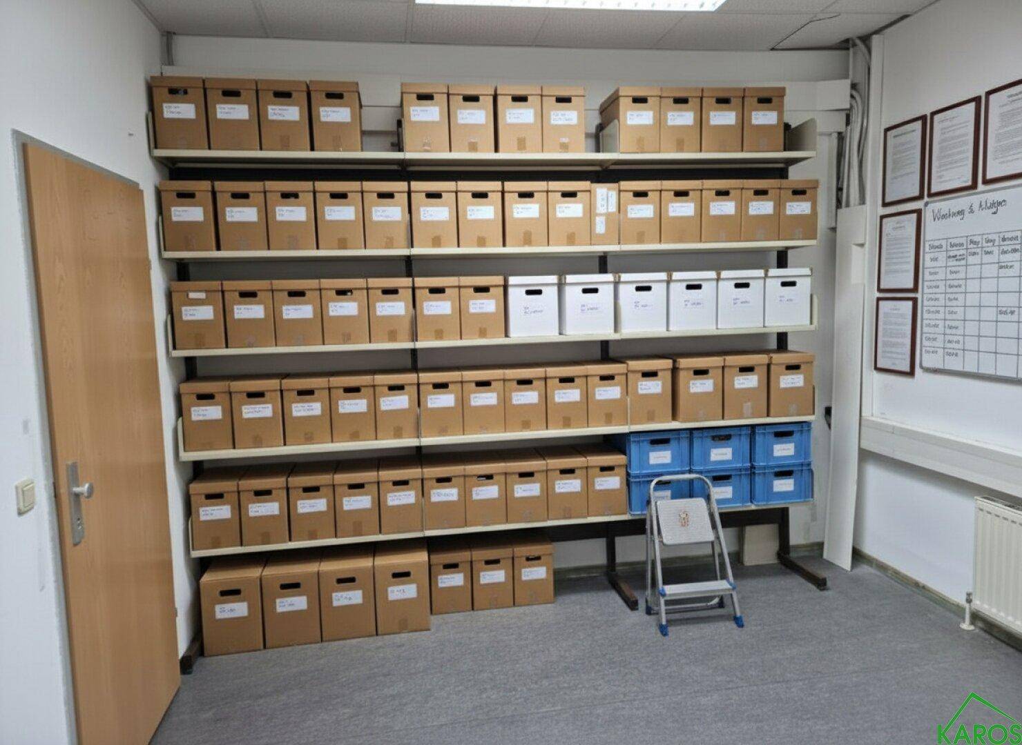 Organisierter Lagerraum mit wandmontierten Regalen, gefüllt mit Archivboxen, bietet viel Stauraum.