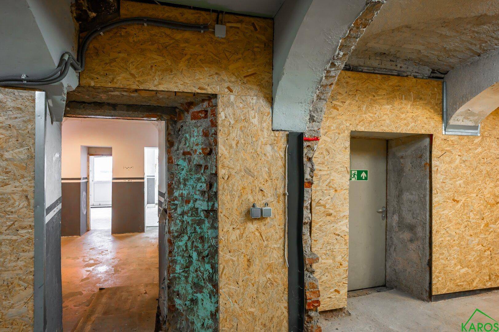 Durchgangsbereich in einem Kellerraum mit unverputzten Wänden und freiliegenden Ziegeln.
