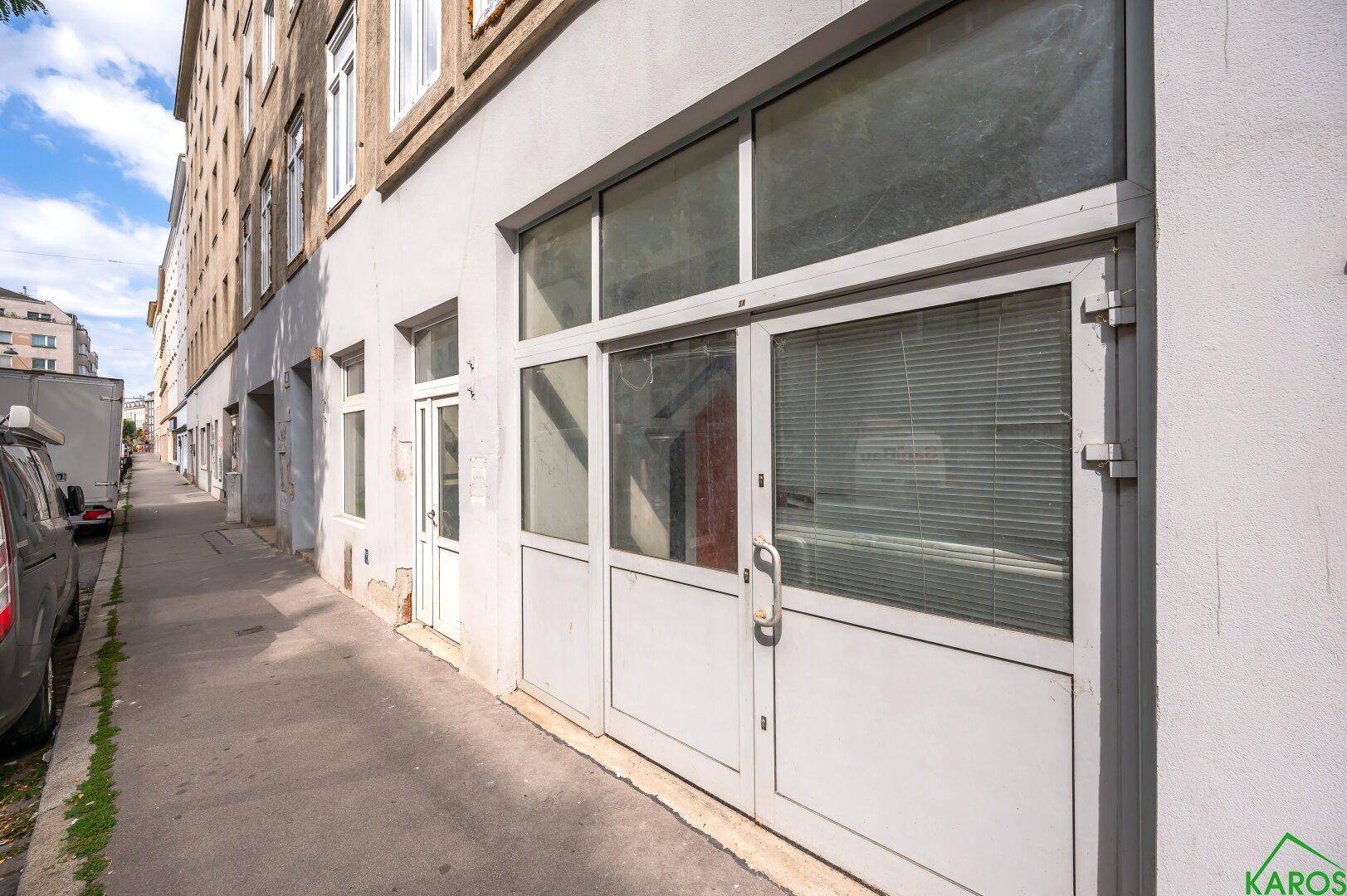 Fassade eines Gebäudes mit großen Fenstern und Eingangstüren entlang der Straße.
