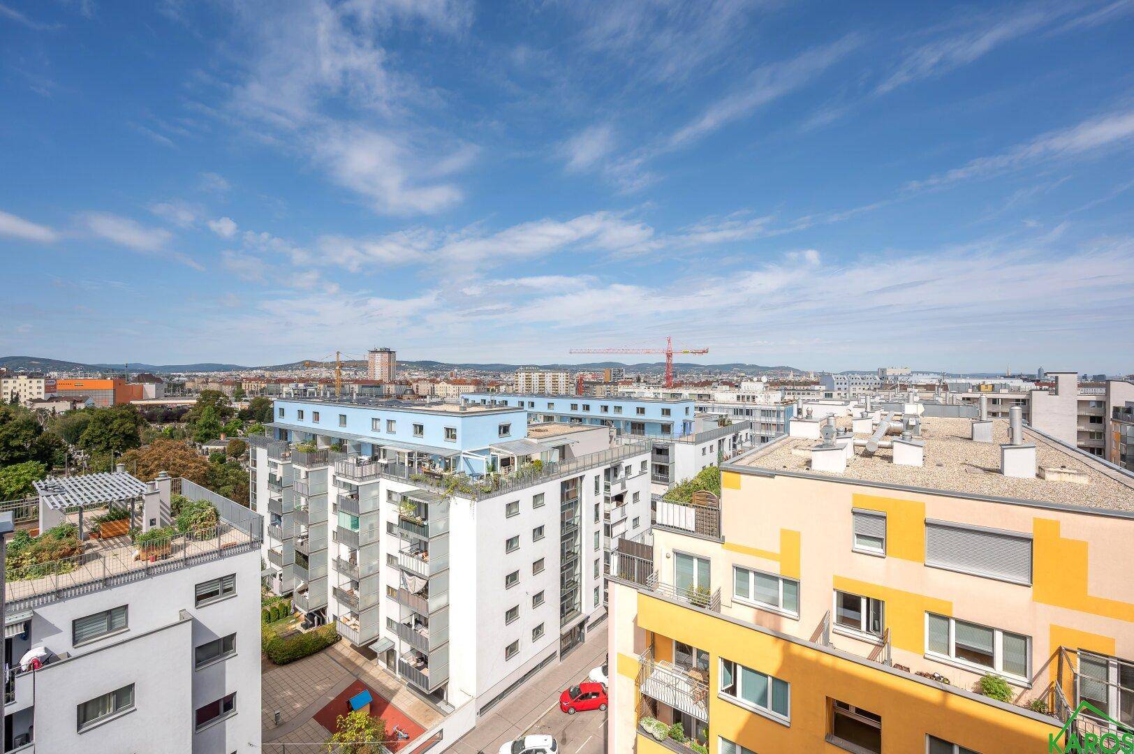 Weitläufiger Blick über eine städtische Skyline mit verschiedenen Wohngebäuden unter blauem Himmel.