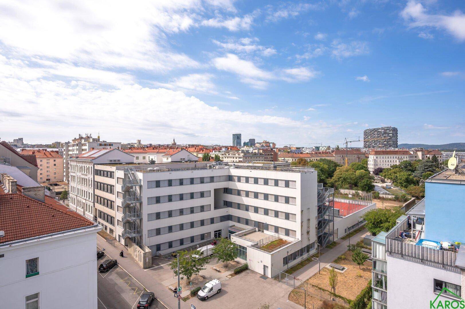Panoramablick über eine städtische Umgebung mit verschiedenen Gebäuden und Grünflächen.