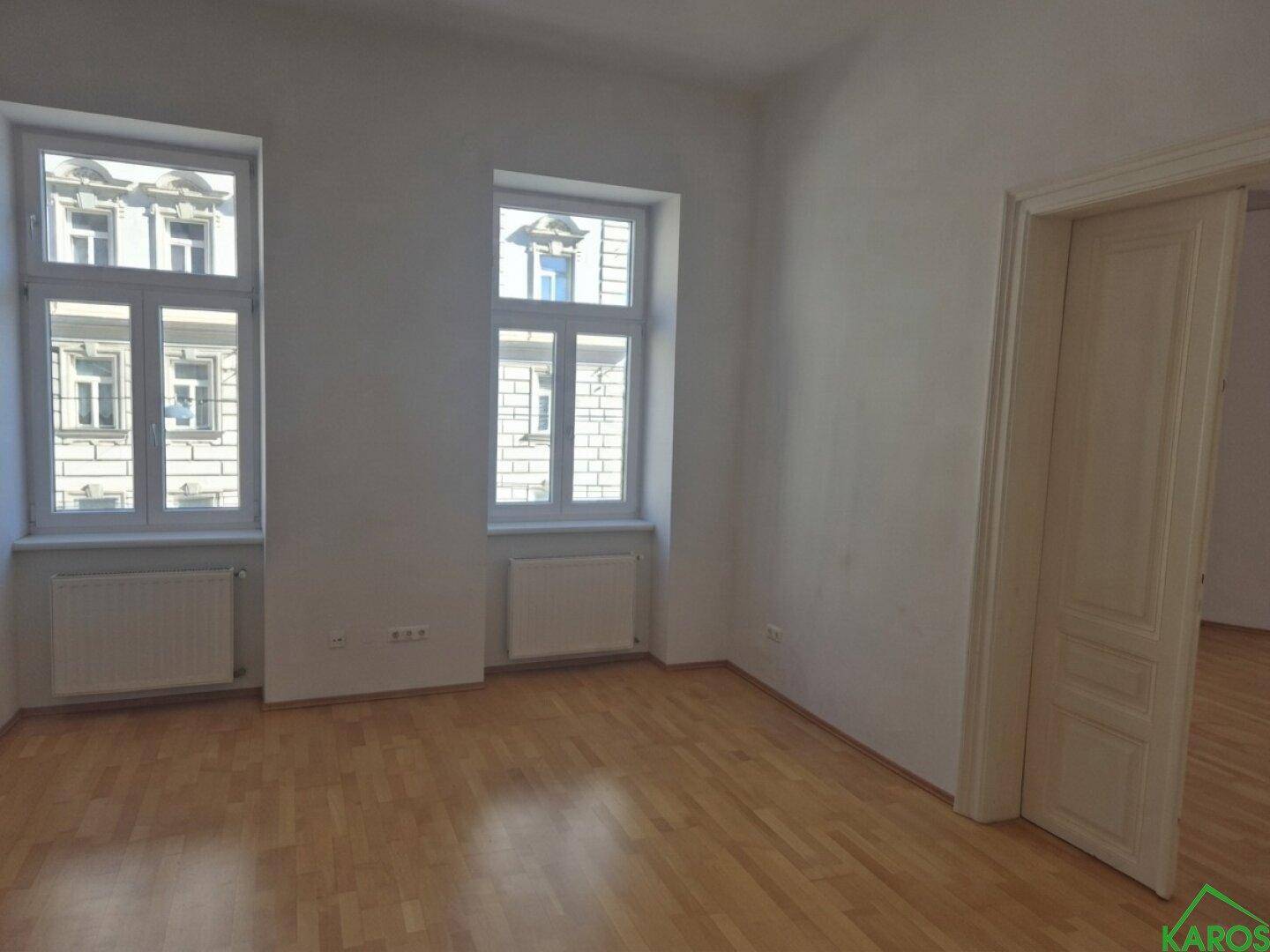 Helles und geräumiges Zimmer mit Parkettboden und zwei Fenstern, die viel Licht spenden.