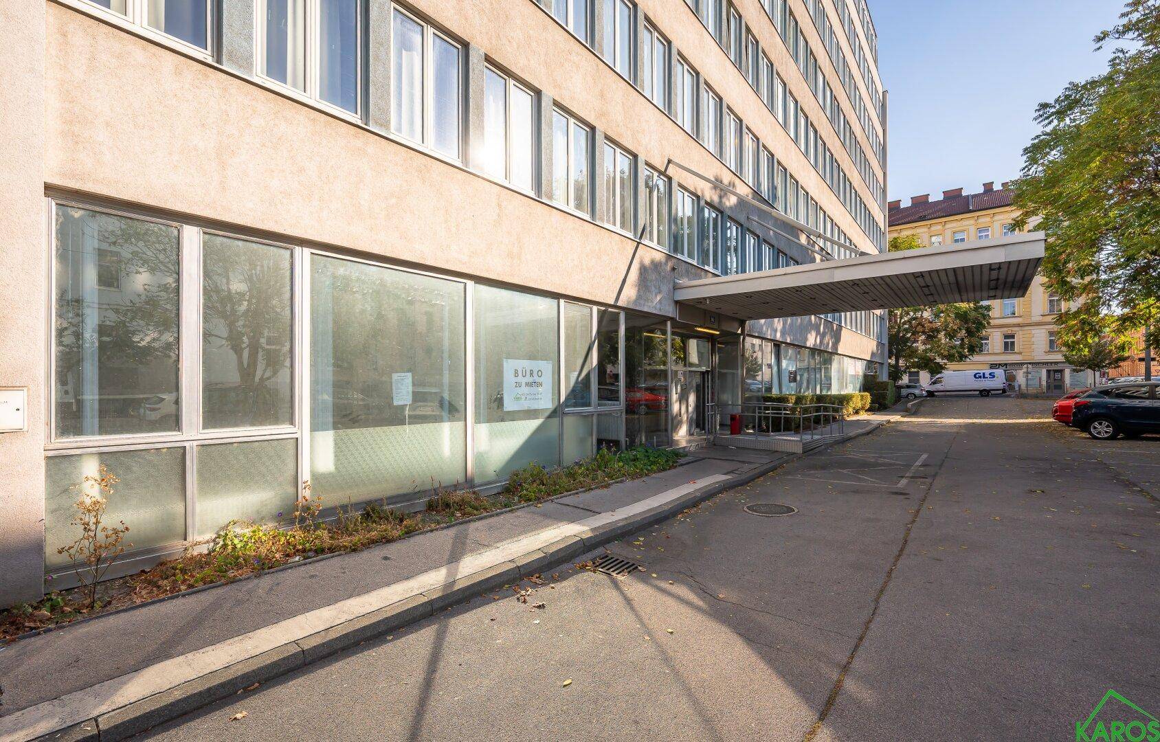 Gesamtansicht des Bürogebäudes mit Eingangsbereich, Parkplätzen und moderner Architektur.