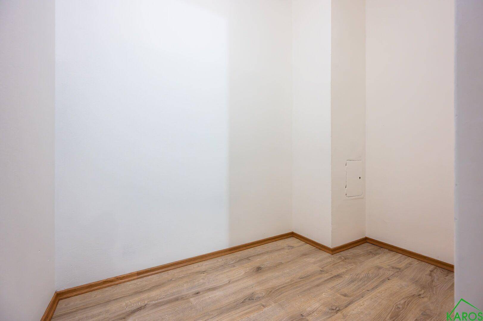 Kleiner, leerer Raum mit Laminatboden und weißen Wänden, ideal als Abstellkammer nutzbar.