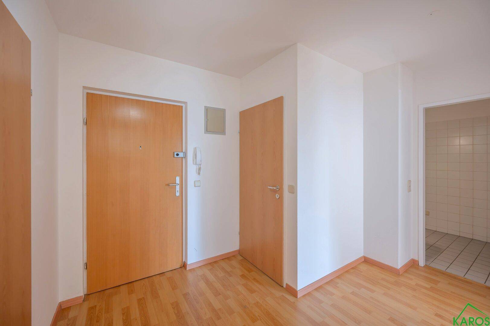 Heller Flur mit Laminatboden und mehreren Türen, die zu den verschiedenen Räumen führen.