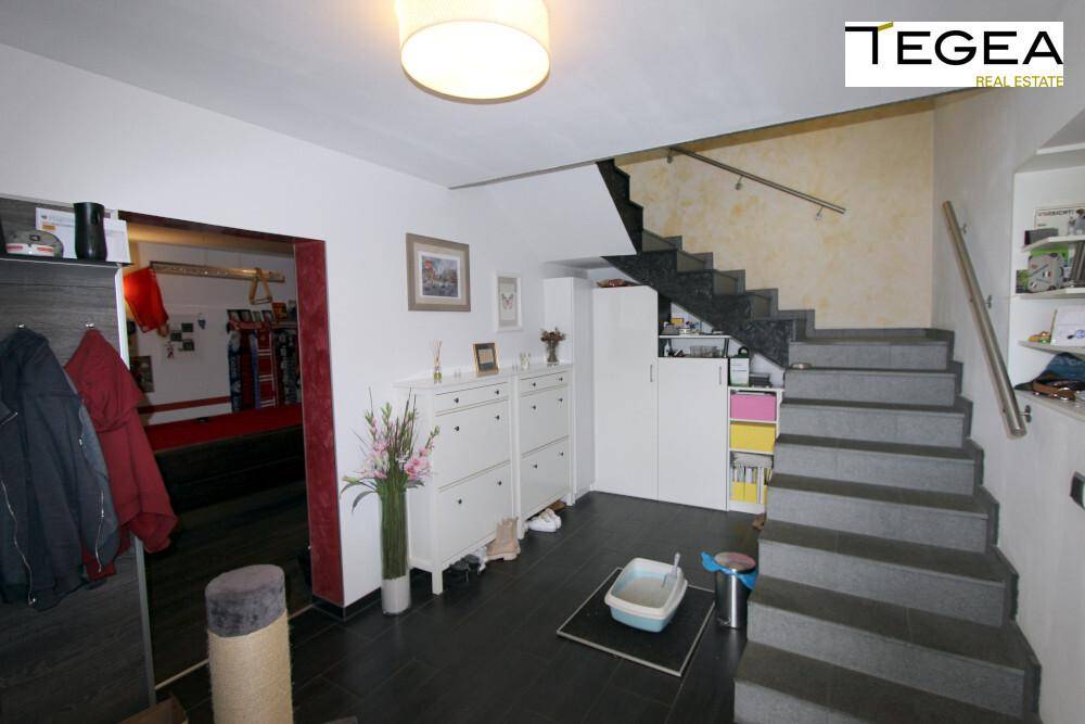 Eingangsbereich mit Treppe zum Obergeschoss und praktischen Schuhschränken.