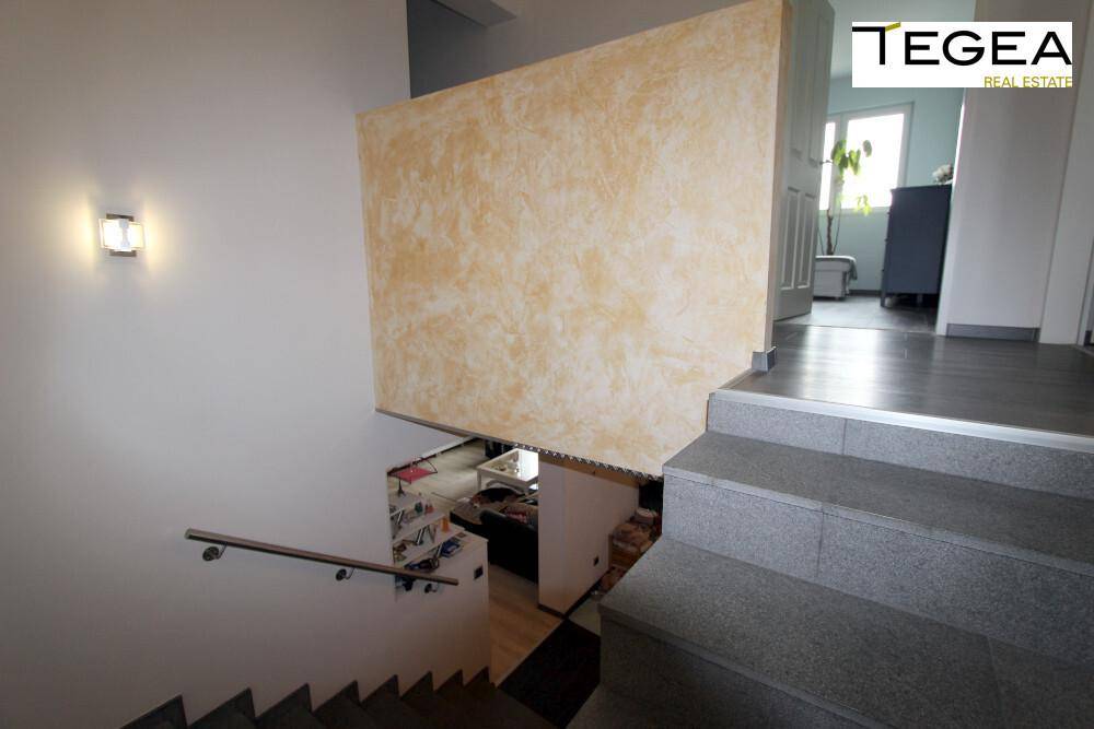 Treppenabsatz mit dekorativer Wandgestaltung und Blick in angrenzende Räume.