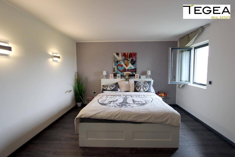 Gemütliches Schlafzimmer mit Doppelbett, modernen Wandleuchten und Fenster.