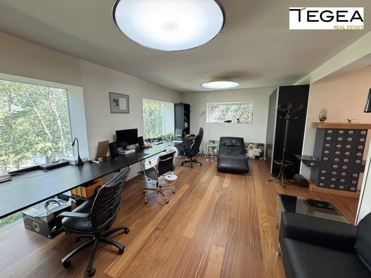 Geräumiges Büro mit großen Fenstern und Holzboden, bietet viel Platz zum Arbeiten.