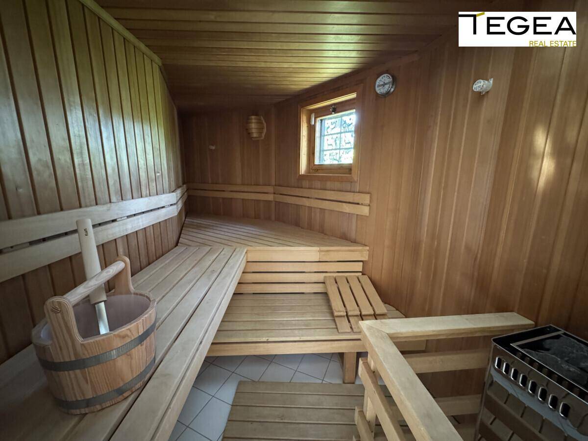 Eine traditionelle Holzsauna mit mehreren Sitzbänken und einem Saunaofen für entspannende Momente.