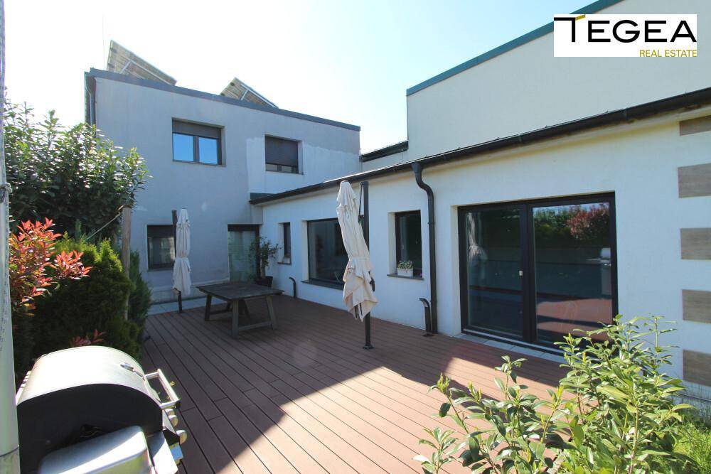 Geräumige Holzterrasse mit Esstisch und Grillbereich, perfekt für Mahlzeiten im Freien.