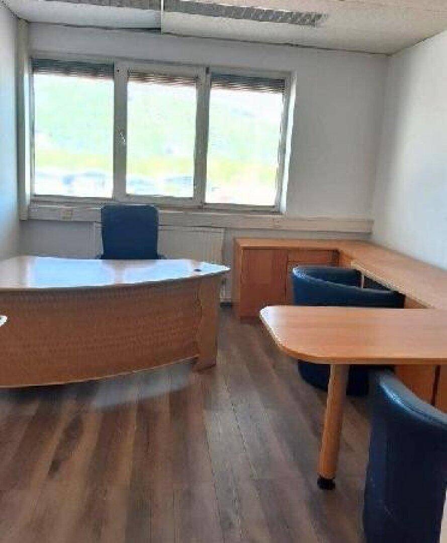 Möblierter Büroraum mit Schreibtischen, Bürostühlen und Laminatboden, der viel Tageslicht erhält.