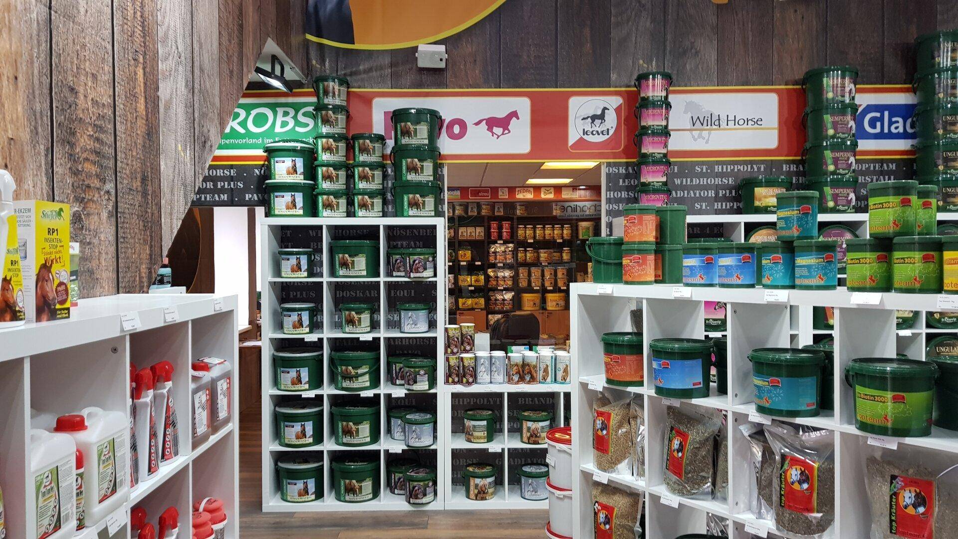 Detailansicht eines Verkaufsregals mit verschiedenen Produkten für Pferde und Haustiere.
