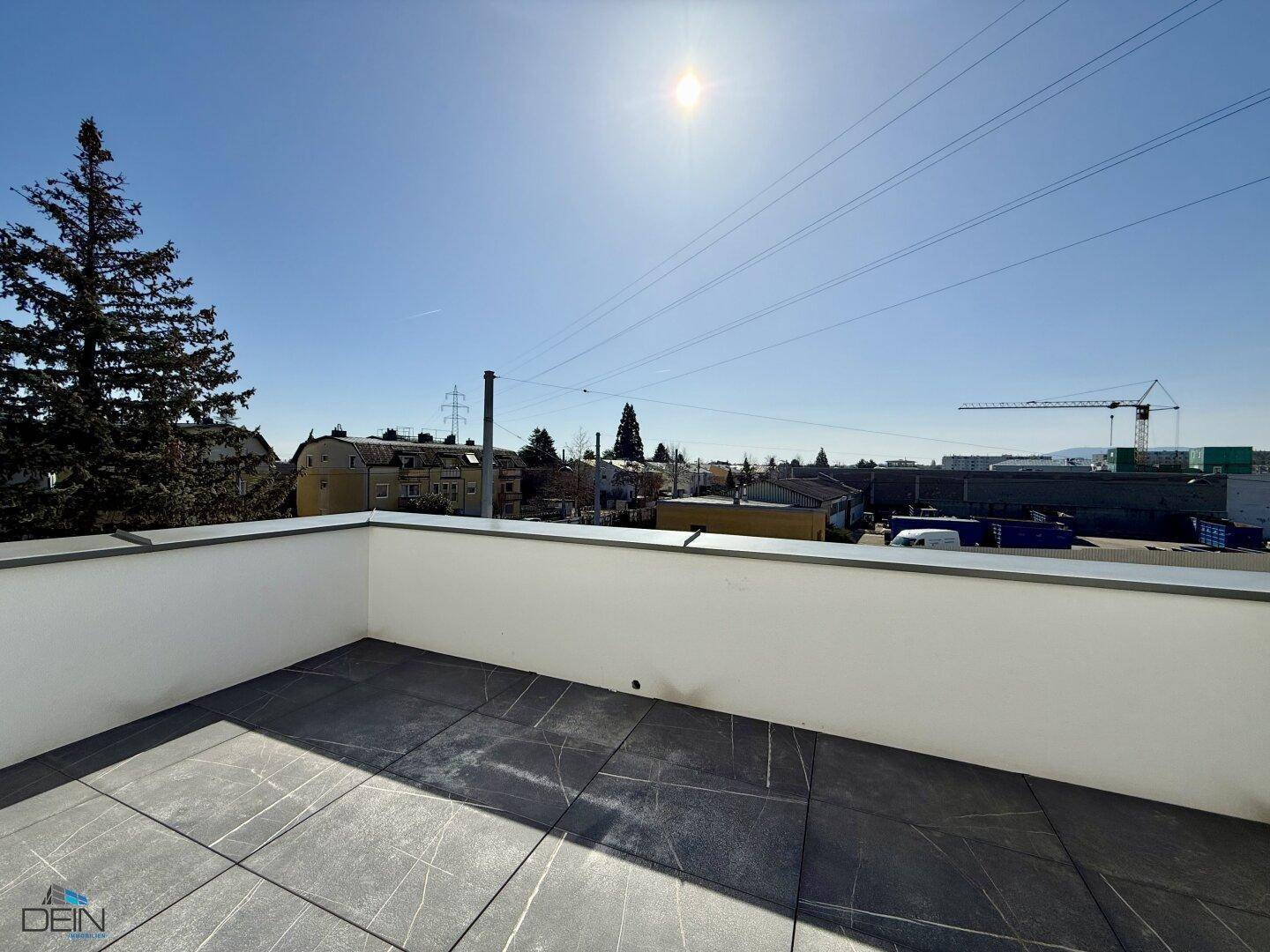 Geräumige Dachterrasse mit Fliesenboden und weitem Blick über die Umgebung.