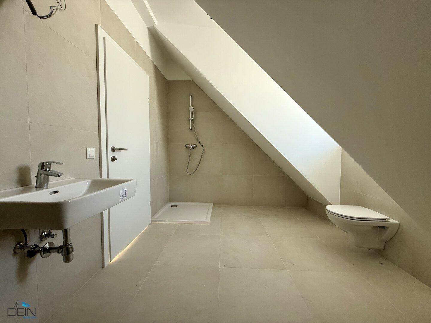 Modernes Badezimmer im Dachgeschoss mit Dusche und schrägen Wänden.