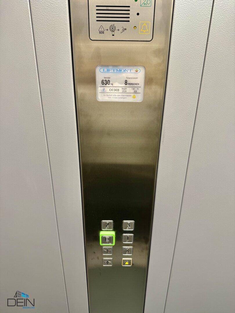 Detailaufnahme des modernen Aufzugbedienfeldes mit Etagenauswahl und Notruffunktion.