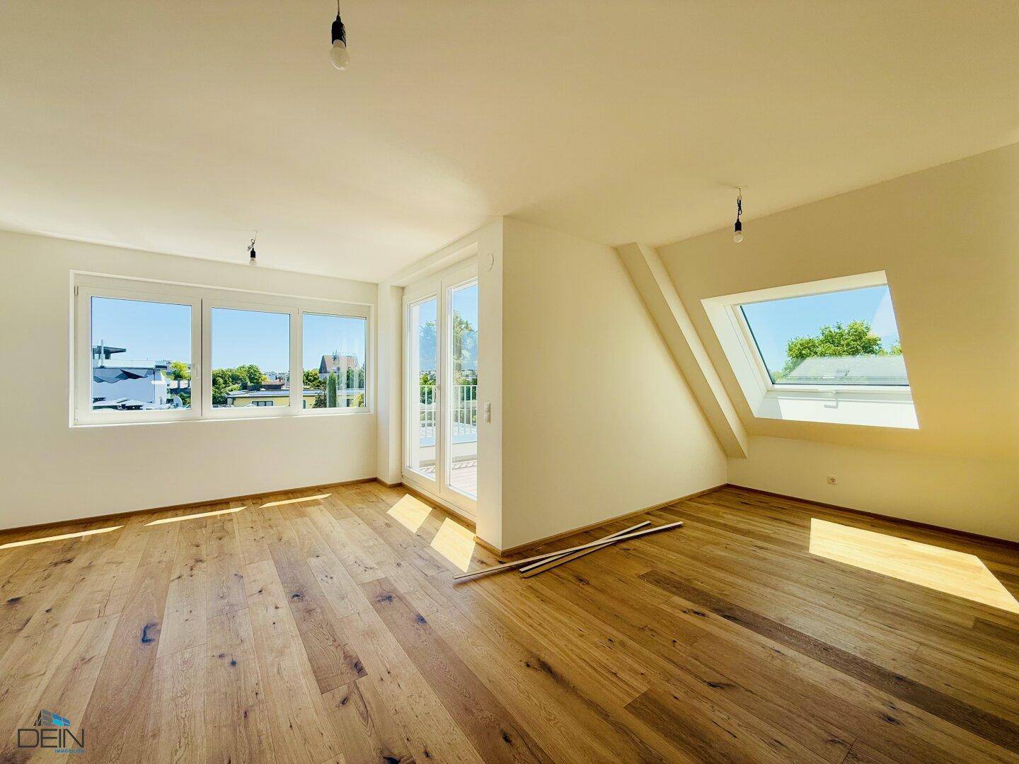 Geräumiges Dachgeschosszimmer mit Holzdielenboden, Dachfenster und viel Tageslicht.