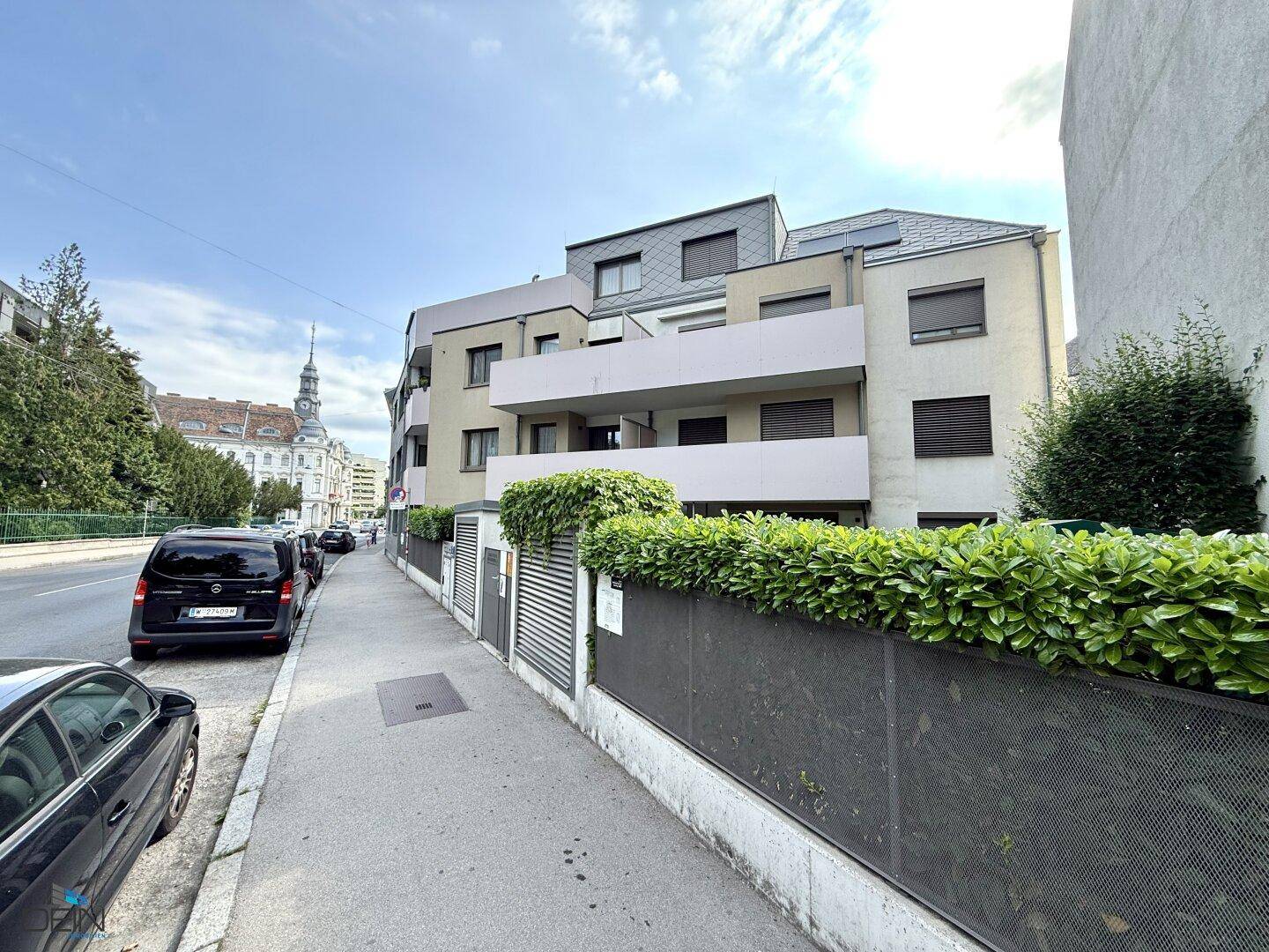 Moderne Wohnhausfassade mit Balkonen und Blick auf die Stadtstraße.