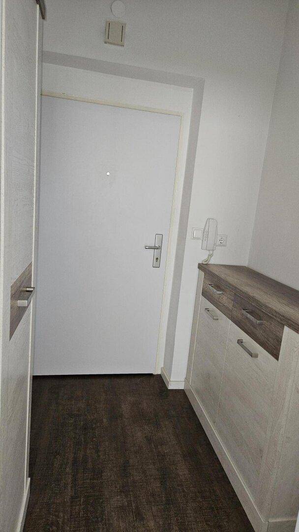 Eingangsbereich mit Haustür, Gegensprechanlage und praktischem Sideboard.