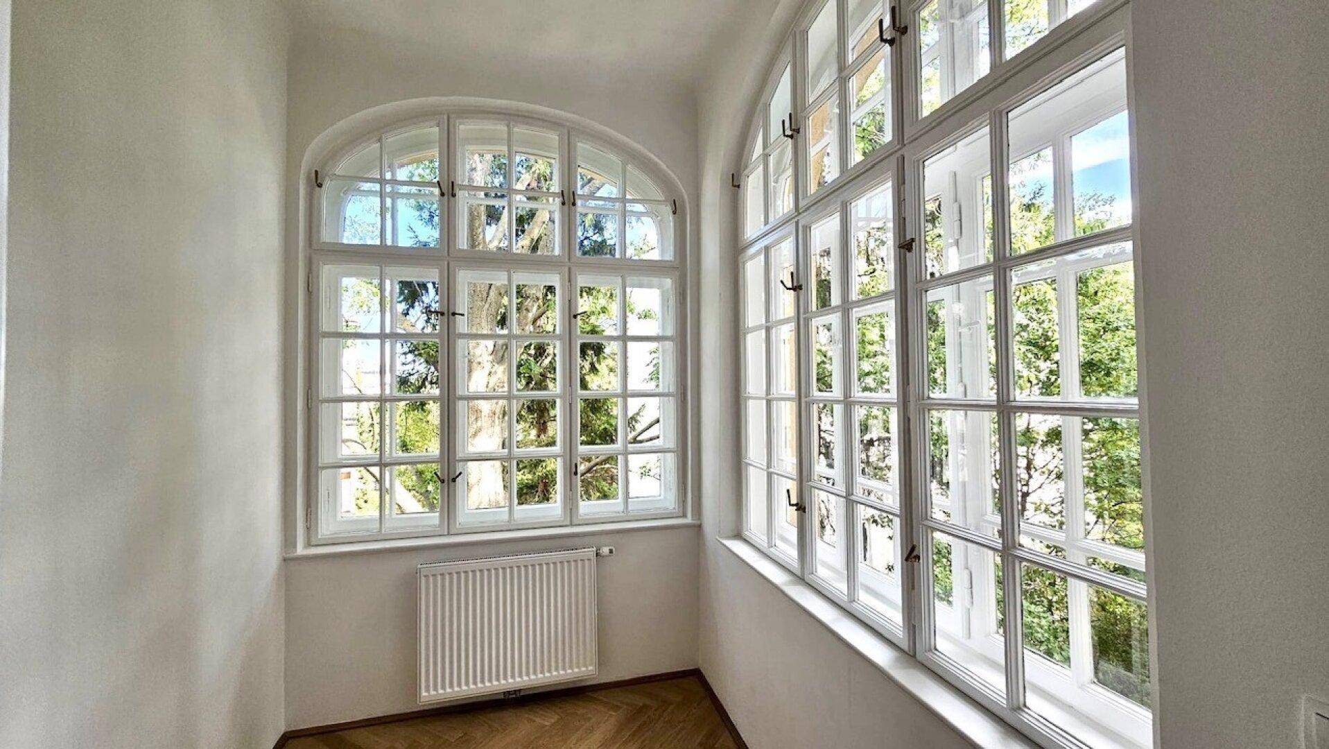 Große, bogenförmige Sprossenfenster bieten einen schönen Blick ins Grüne und viel Tageslicht.
