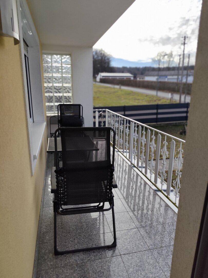Kleiner Balkon mit Fliesenboden und Metallgeländer, ideal für entspannte Stunden im Freien.