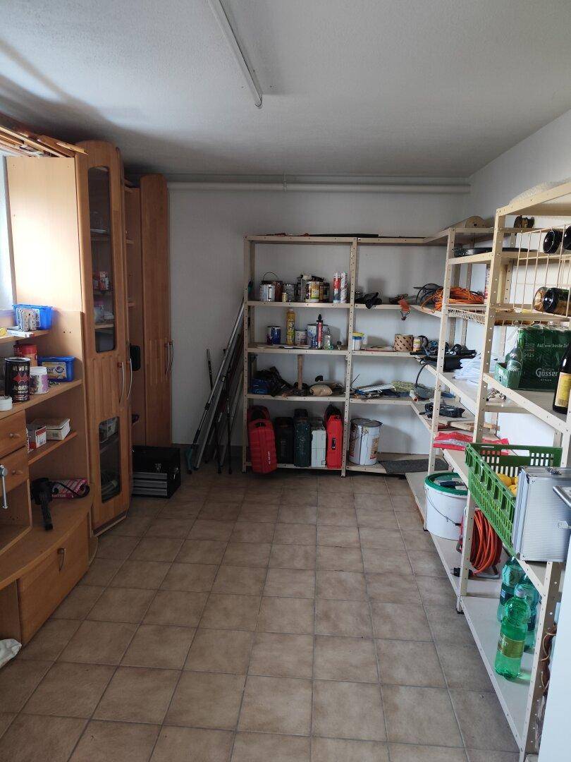 Praktischer Abstellraum mit Regalen für Lagerung und Fliesenboden.
