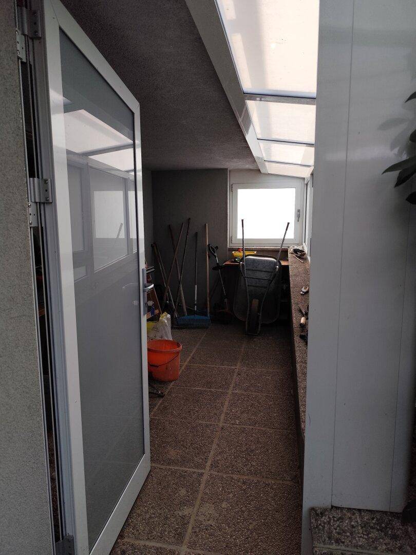 Heller Wintergarten oder Abstellraum mit Fenster und Zugang zum Außenbereich.