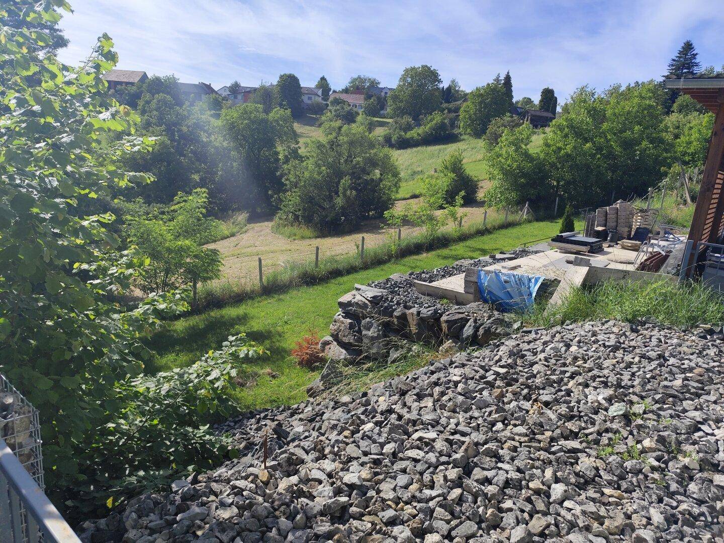 Naturbelassener Gartenbereich mit Felsen und Bäumen, bietet einen grünen Ausblick.