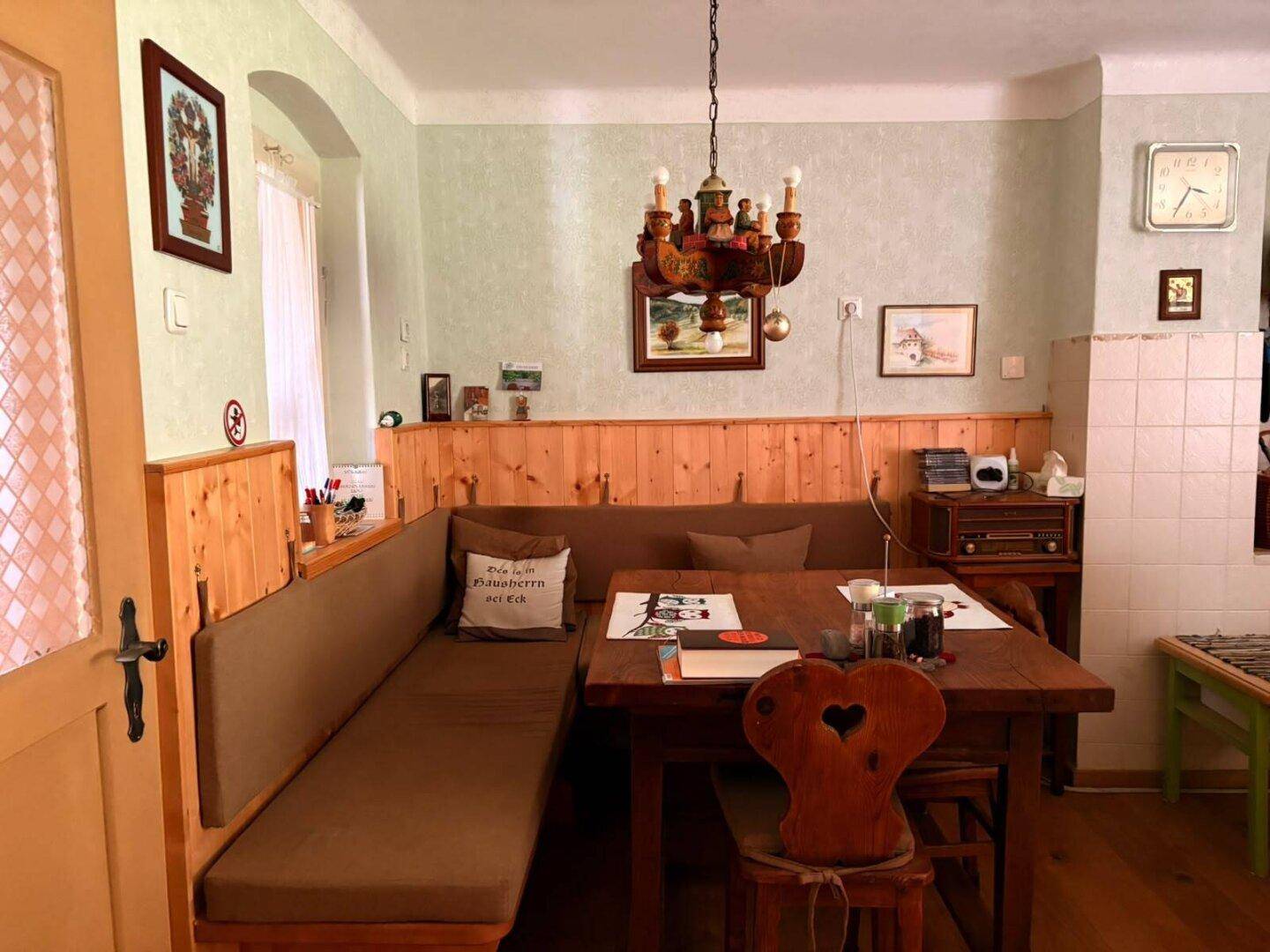 Gemütlicher Essbereich mit Eckbank, Holztisch und traditioneller Holzvertäfelung.