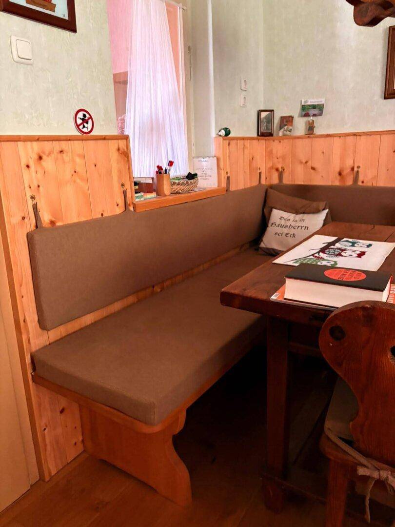 Detailansicht des Essbereichs mit bequemer Eckbank und rustikaler Holzvertäfelung.