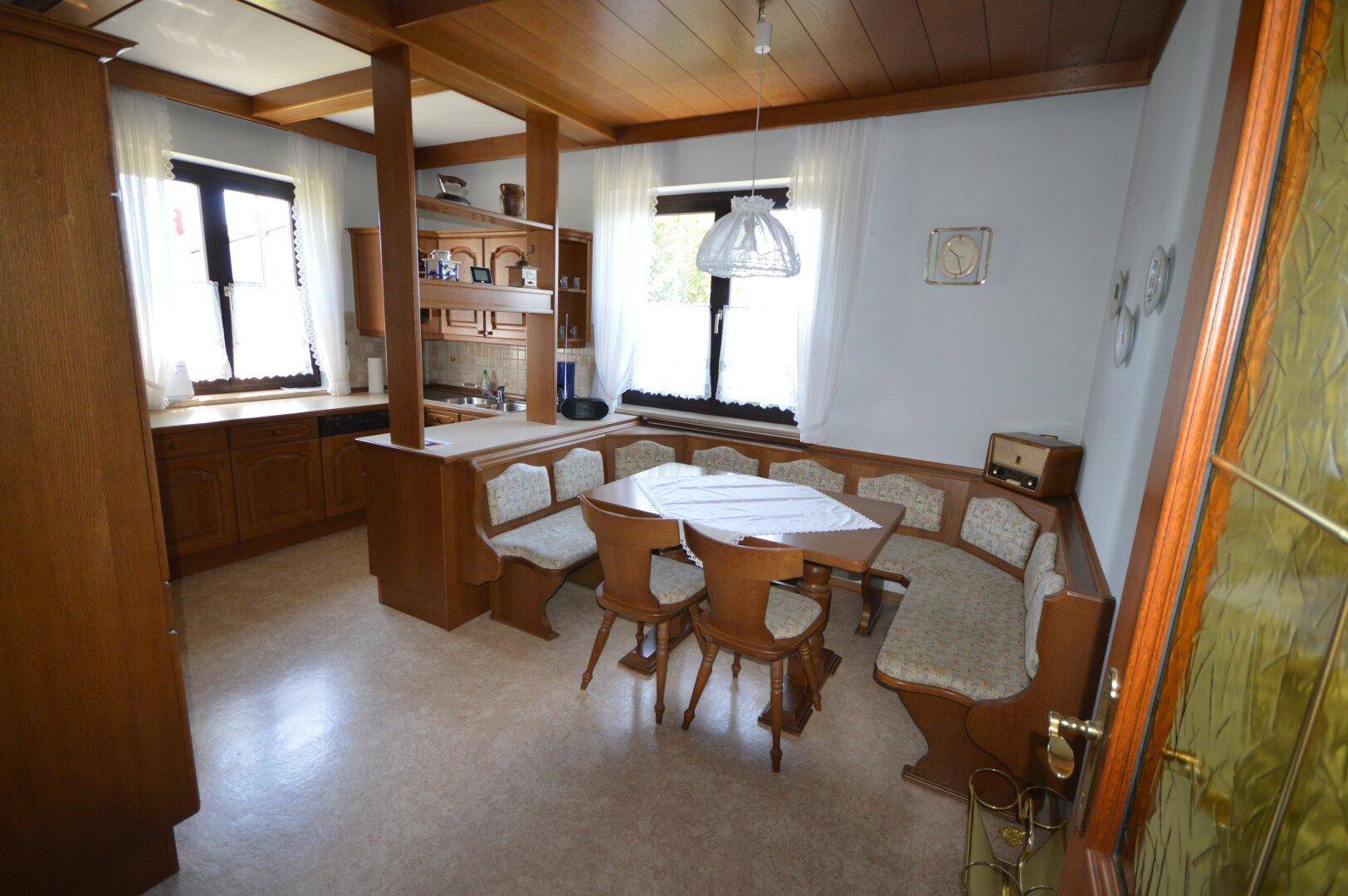 Gemütliche Küche im traditionellen Stil mit Holzeinbauten, Eckbank und Fenster.