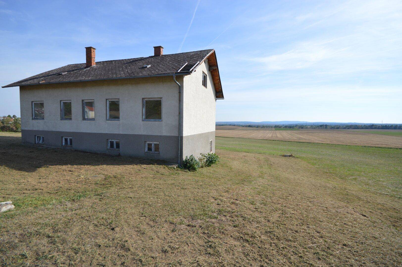 Seitenansicht des Hauses mit weitem Blick über Felder und ländliche Landschaft.