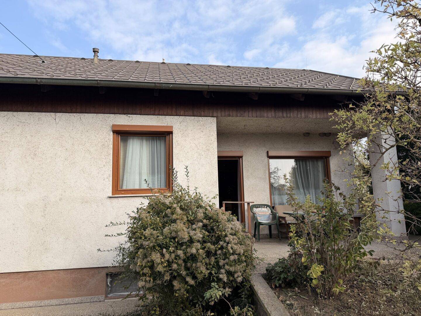 Überdachte Terrasse mit Sitzgelegenheiten und Blick in den Garten.