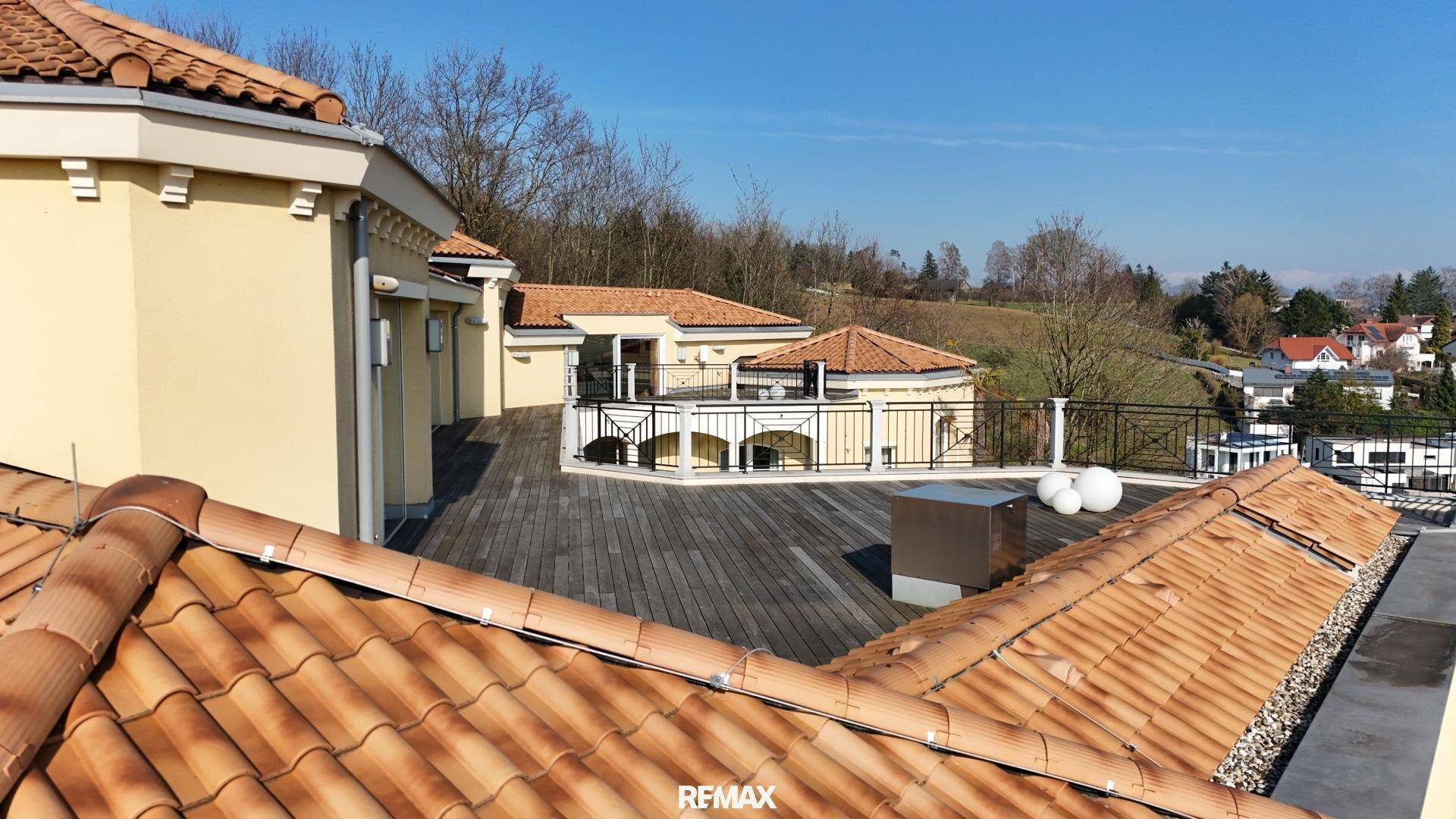 Weitläufige Dachterrasse mit Holzboden und Panoramablick über die umliegende Landschaft.