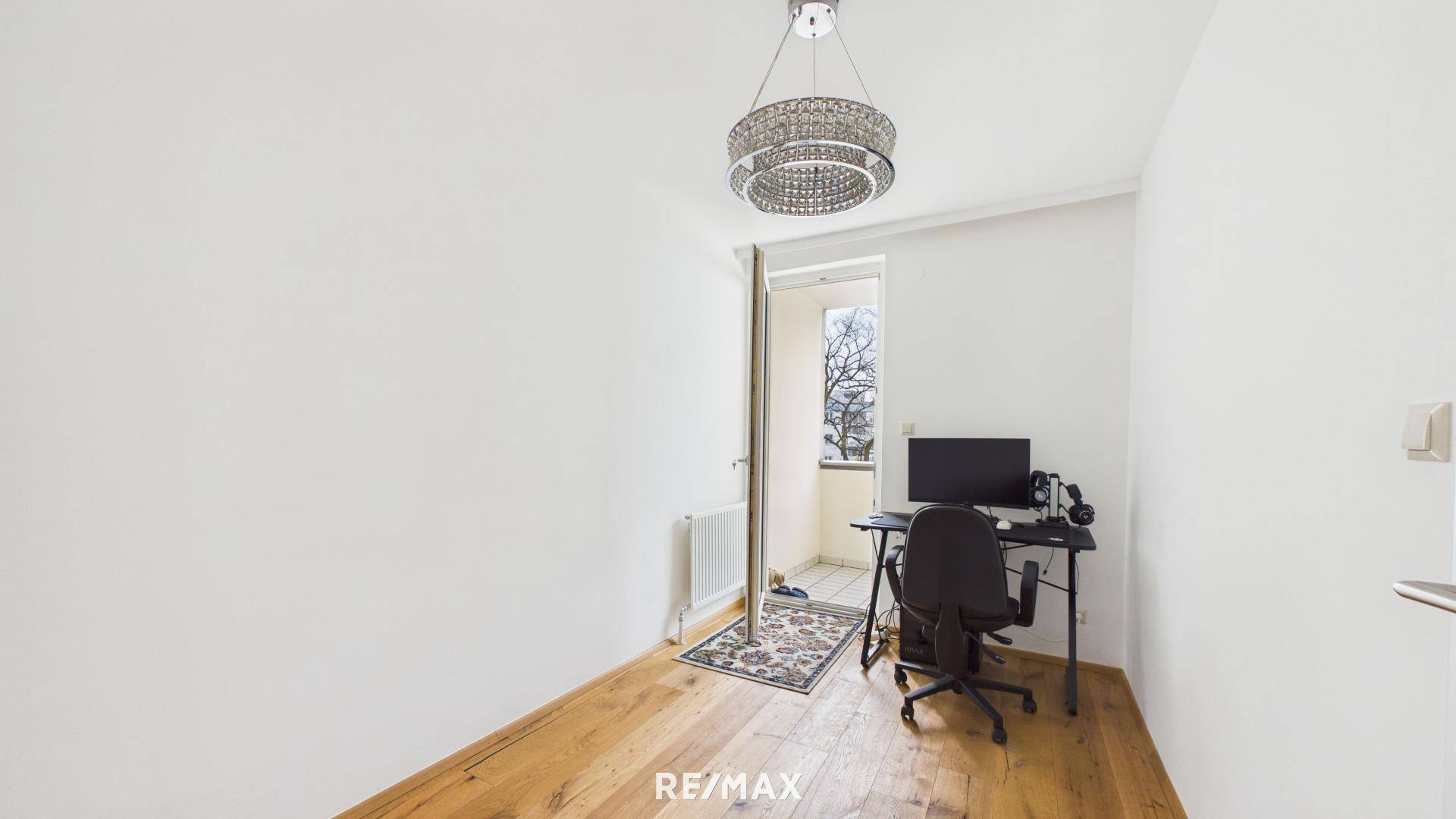 Arbeitszimmer mit Schreibtisch, Bürostuhl und Zugang zu einem französischen Balkon.