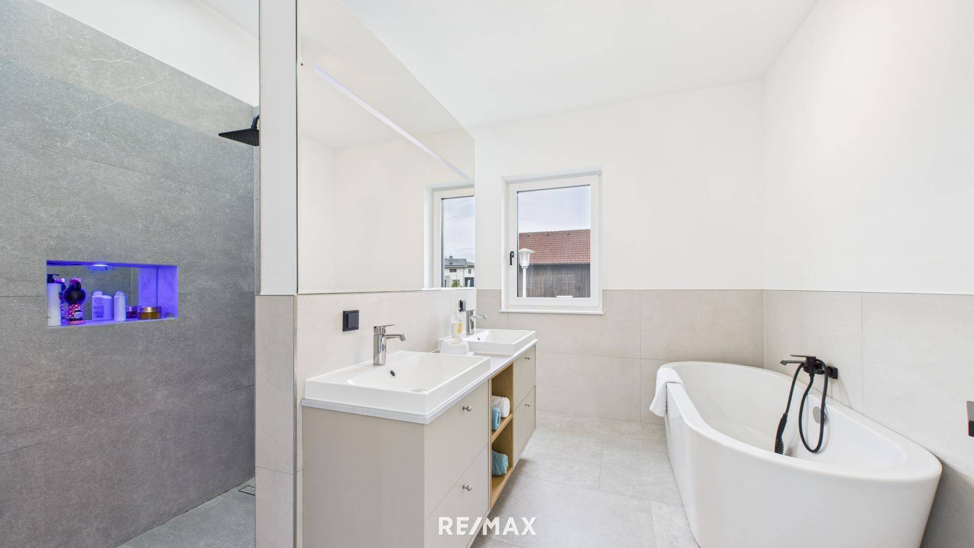 Geräumiges modernes Badezimmer mit freistehender Badewanne, Doppelwaschbecken und großer Dusche.