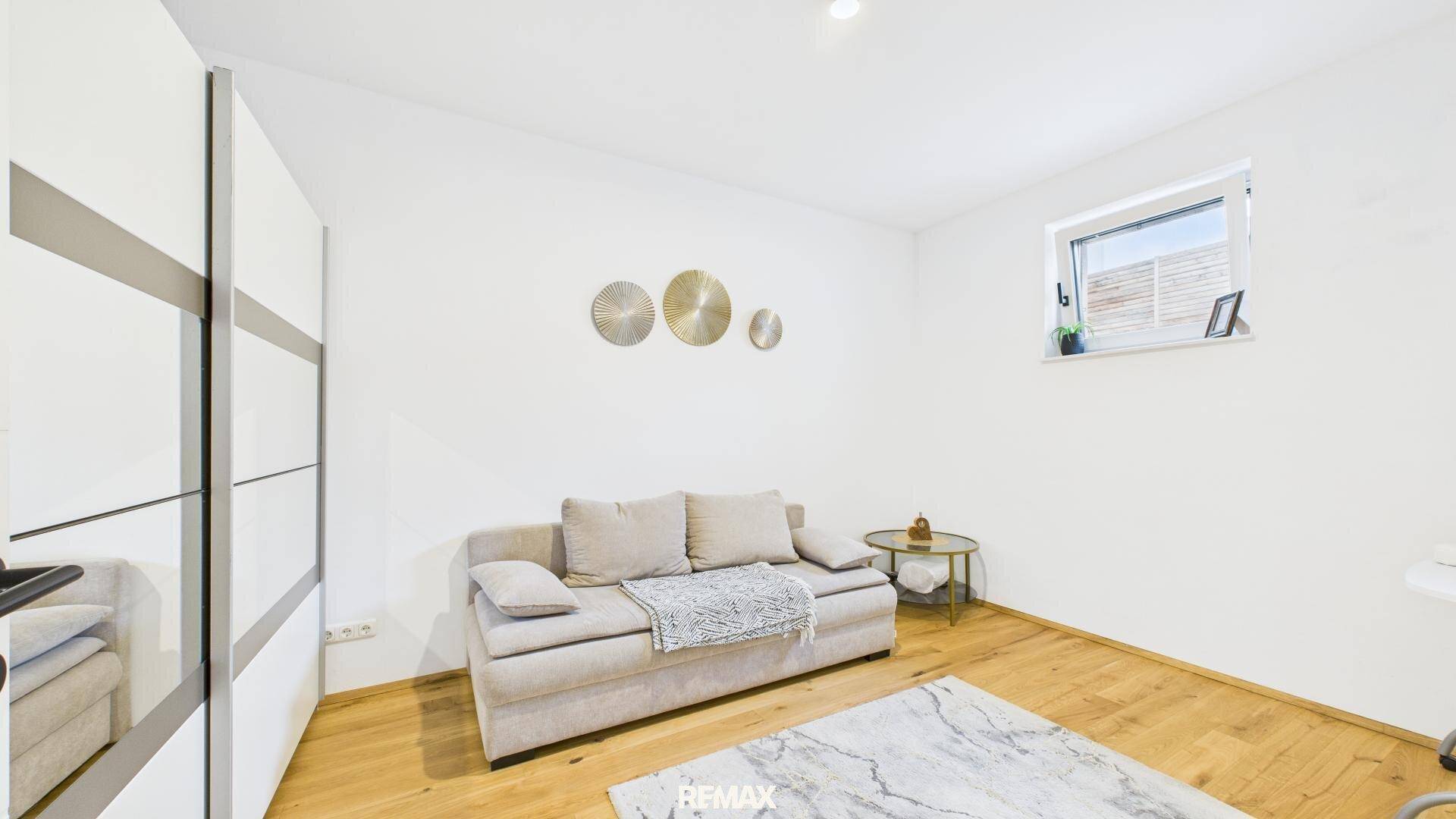 Gemütliches Zimmer mit Schlafsofa, Einbauschrank und hellem Holzfußboden.