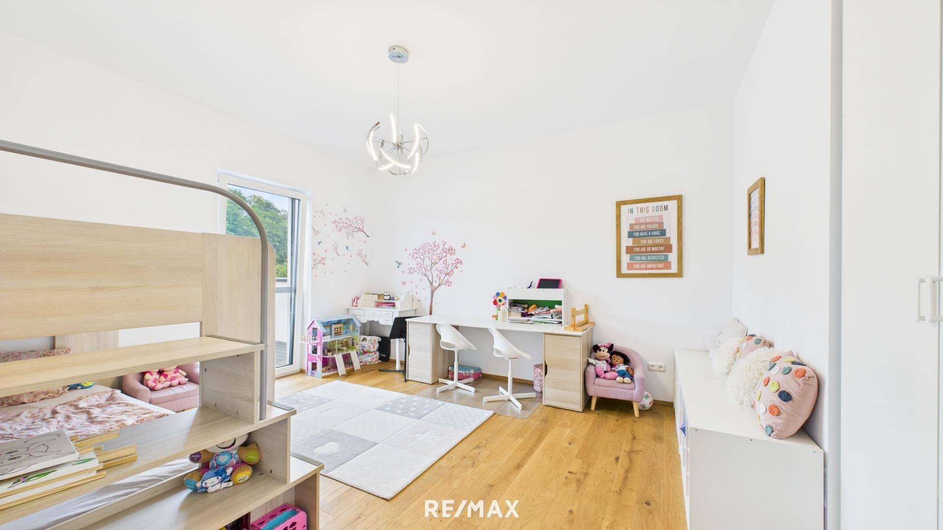 Freundliches Kinderzimmer mit Etagenbett, Schreibtisch und verspielter Wanddekoration.