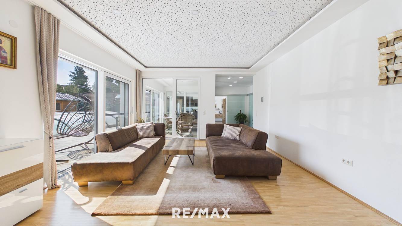Lichtdurchflutetes Wohnzimmer mit Zugang zur Terrasse und Blick in den Garten.