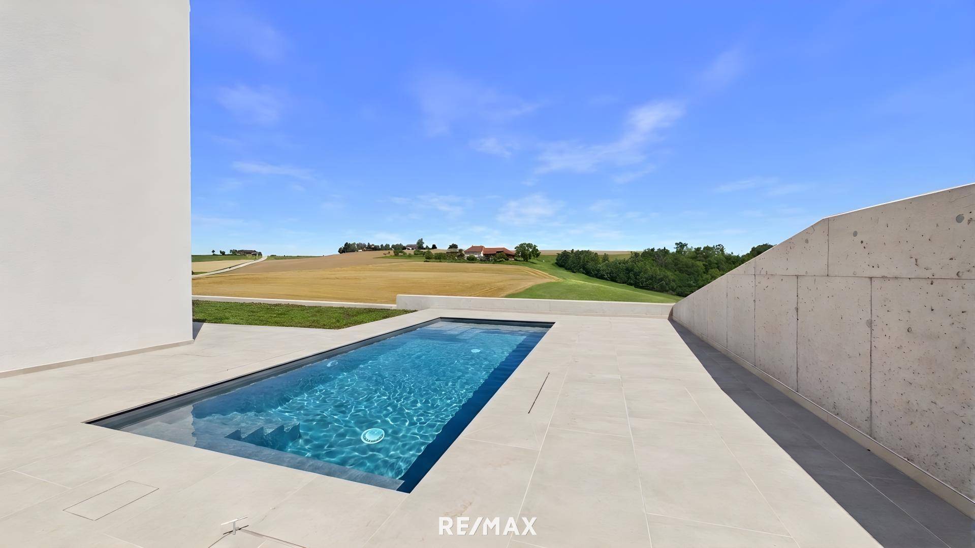 Elegante Terrasse mit eingelassenem Pool und weitem Blick über die umliegende Landschaft.