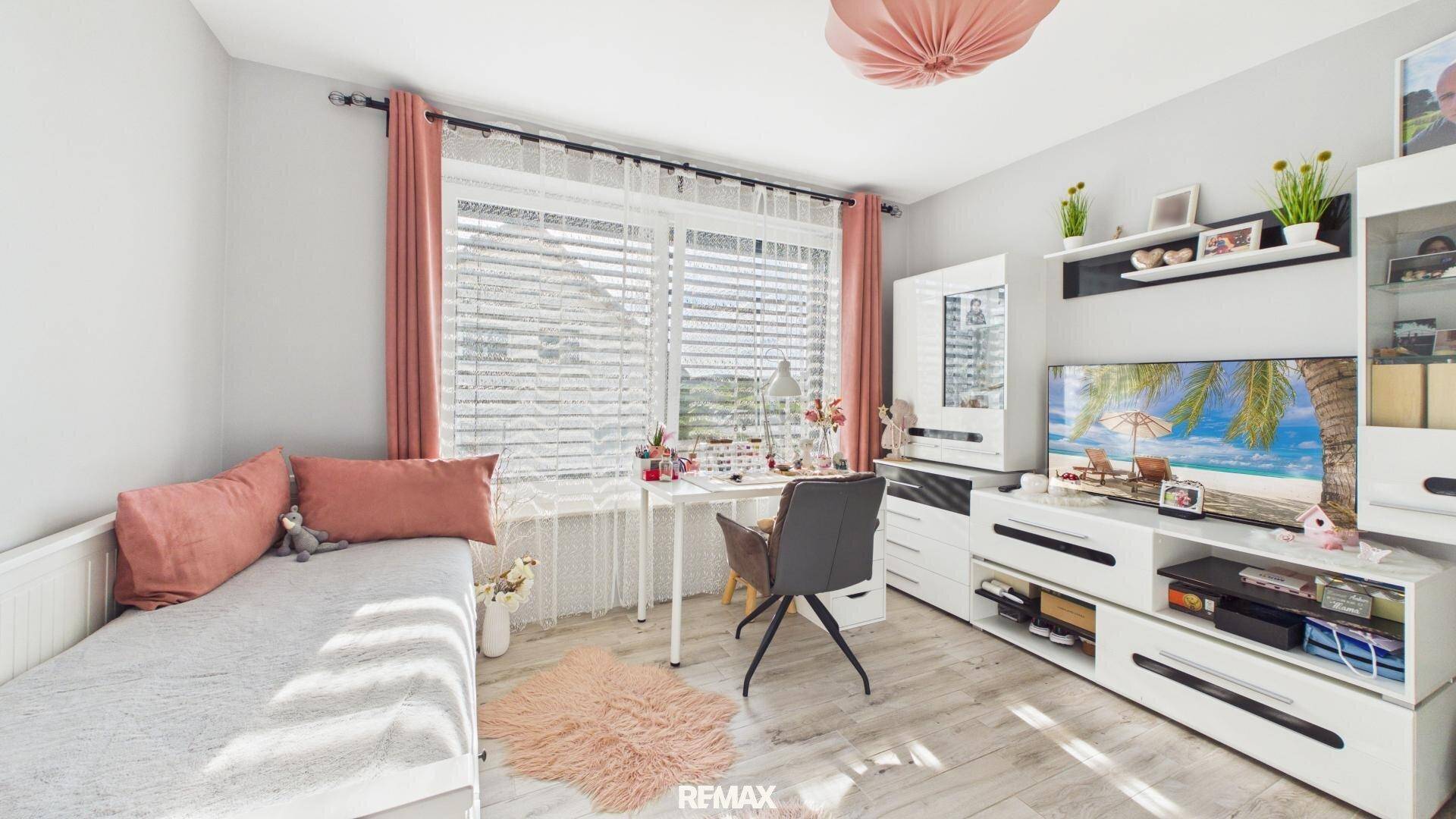 Freundliches Kinderzimmer mit Schreibtisch, Stauraum und viel Tageslicht.