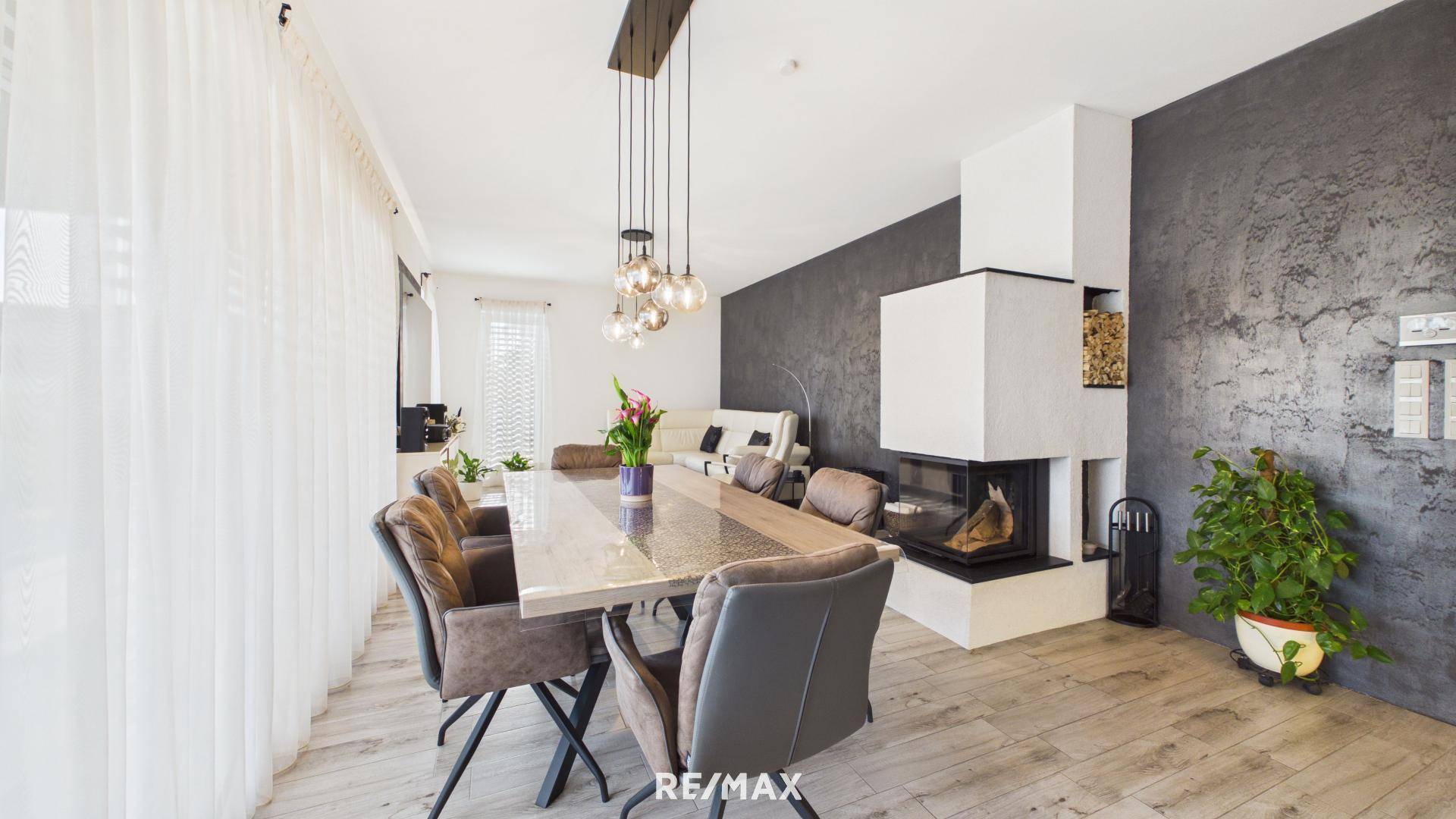 Eleganter Essbereich mit großem Tisch, modernen Stühlen und einem integrierten Kamin.