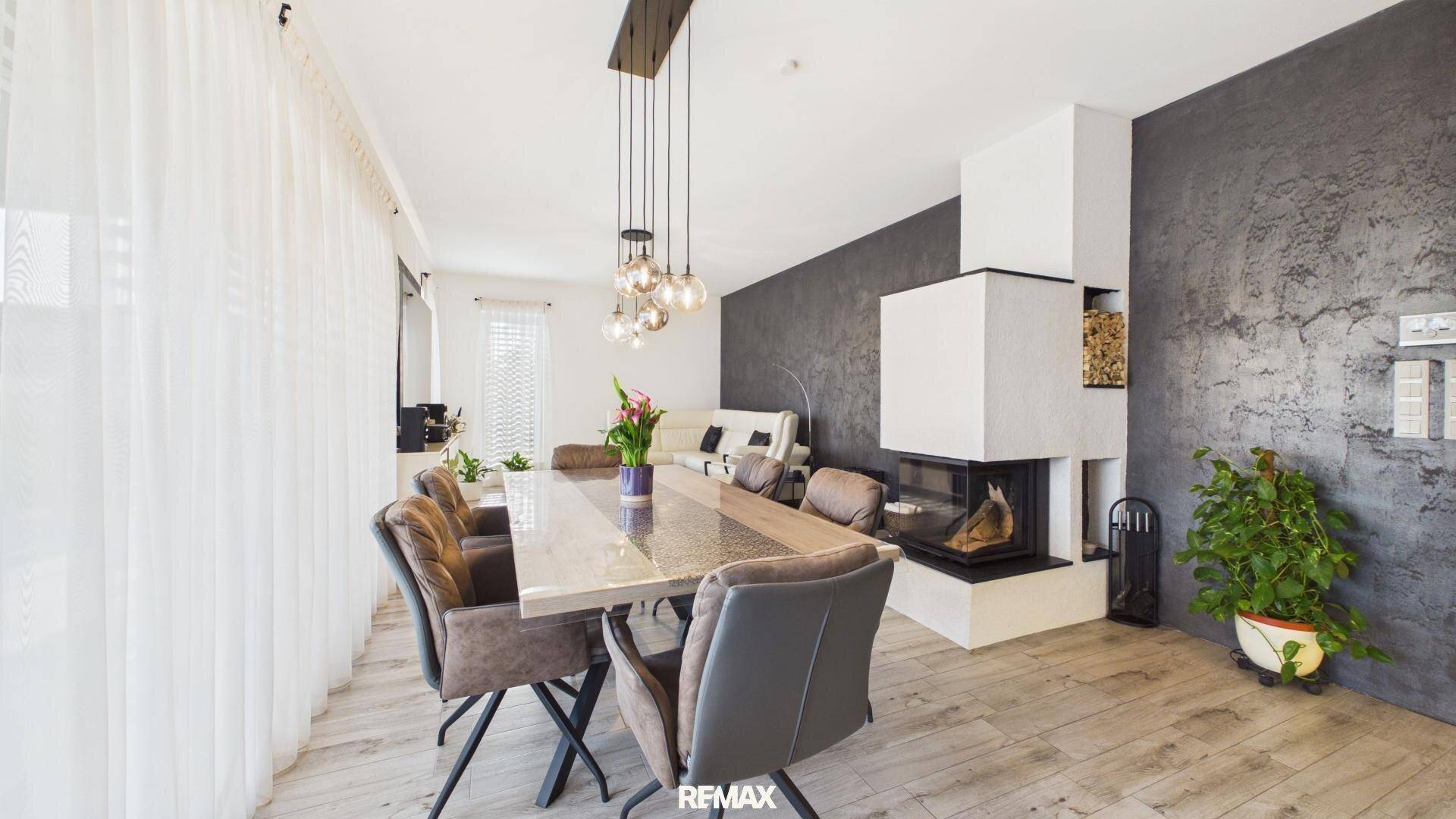 Eleganter Essbereich mit großem Tisch, modernen Stühlen und einem integrierten Kamin.