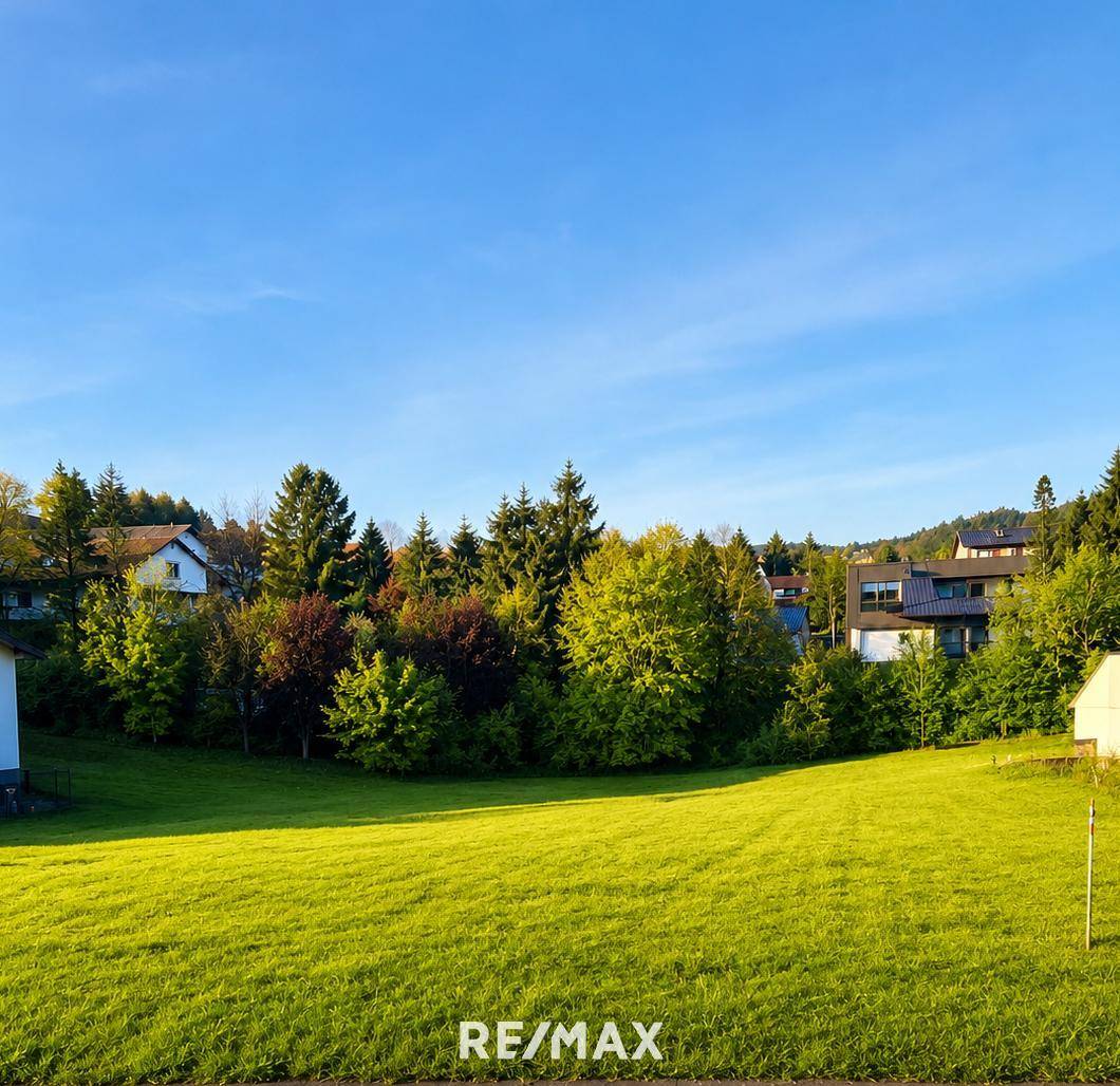Sonniges Grundstück mit weitem Blick ins Grüne und umgeben von Bäumen und Häusern.