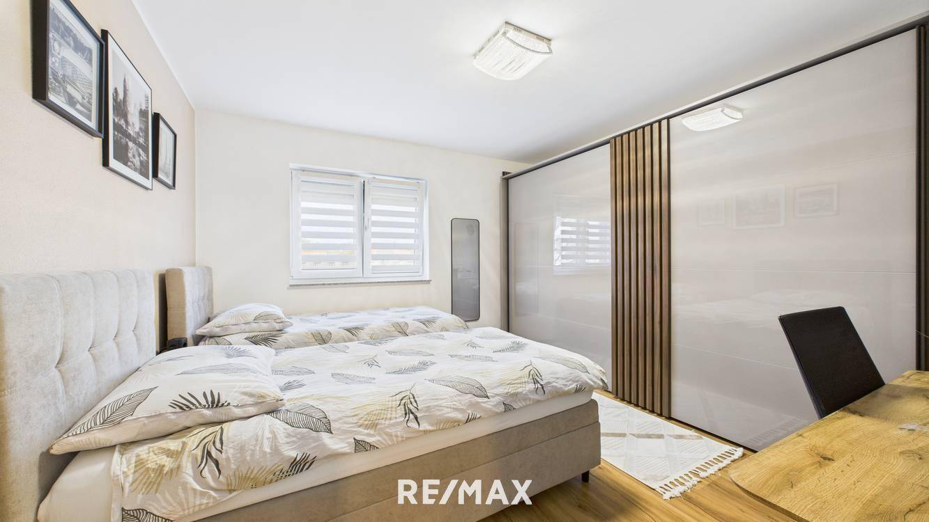 Helles Schlafzimmer mit zwei Einzelbetten, Holzboden und großem Schiebetürenschrank.
