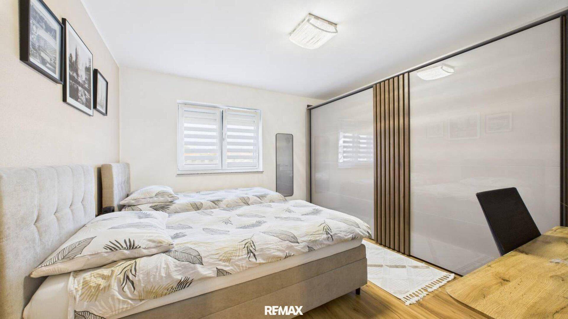 Gemütliches Schlafzimmer mit zwei Einzelbetten, großem Schiebetürenschrank und Laminatboden.