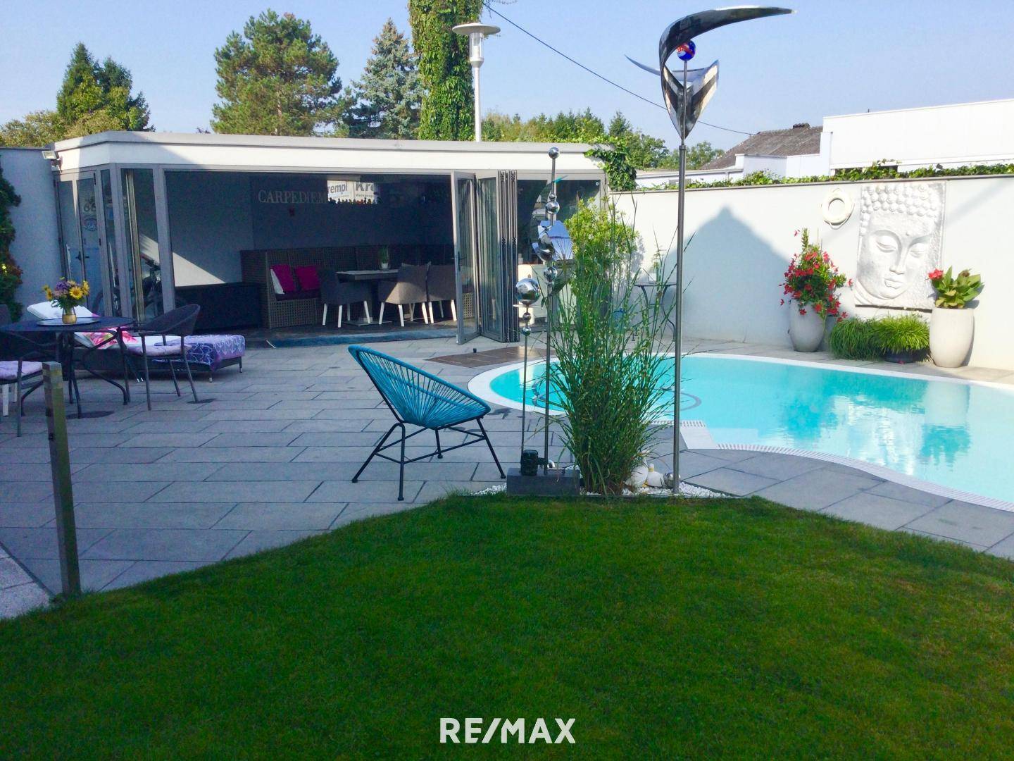Gepflegter Gartenbereich mit Swimmingpool, Terrasse und gemütlicher Sitzecke für entspannte Stunden.