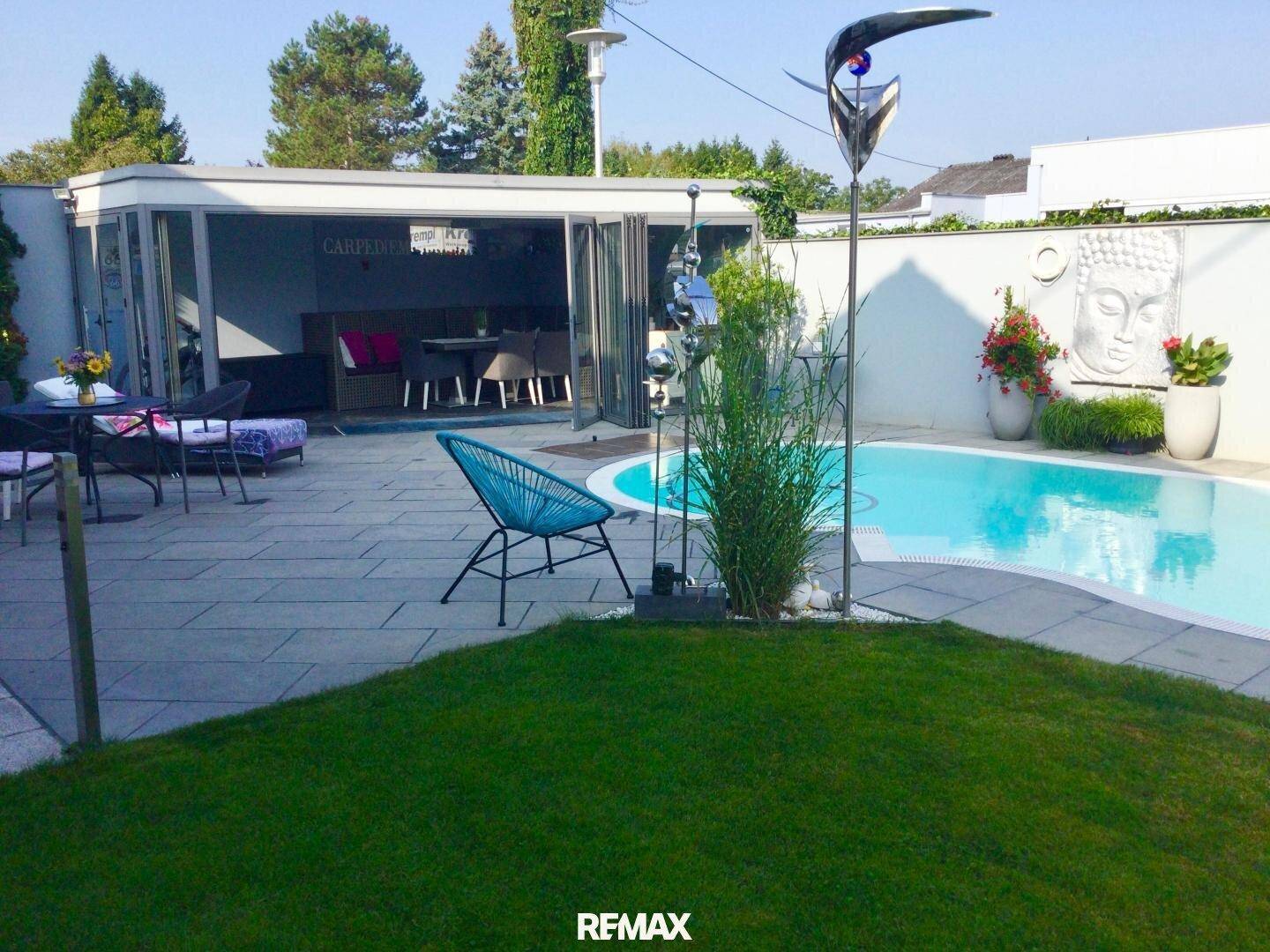 Gepflegter Gartenbereich mit Swimmingpool, gepflasterter Terrasse und gemütlicher Outdoor-Lounge.
